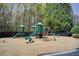 Community playground with climbing structures, slides, and swings surrounded by lush greenery at 1111 Newpark View Pl, Mableton, GA 30126