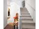 Bright staircase featuring white railing and neutral carpet with decor at 11169 James Madison Dr, Hampton, GA 30228