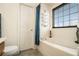 Bathroom featuring a white tub, a window, and a towel rack at 665 Sable View Ln, Atlanta, GA 30349