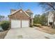 Traditional home with stacked stone accents, a two-car garage, and a concrete driveway at 665 Sable View Ln, Atlanta, GA 30349