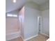 Bright bathroom featuring a white bathtub, shower, and natural light from the window at 6716 Browns Mill Ferry Dr, Lithonia, GA 30038