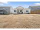 Home's backyard featuring dry grass, a patio, and a view of neighboring houses at 2030 Vidalia Court, Dacula, GA 30019