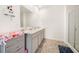 Well-lit bathroom featuring double sinks, modern vanities, and a glass-enclosed shower, offering convenience and style at 2030 Vidalia Court, Dacula, GA 30019