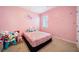 Charming pink bedroom featuring a cozy bed, a bright window, and a personalized decor at 2030 Vidalia Court, Dacula, GA 30019
