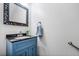 Stylish half bathroom with a blue vanity, granite countertop, and decorative mirror at 6119 Fairlong Nw Run, Acworth, GA 30101