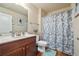 Bathroom with wood cabinets, white sink, and shower with decorative curtain at 6119 Hickory Lane Dr, Union City, GA 30291
