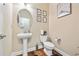 Cozy half-bathroom with a pedestal sink, toilet, wood floors, and decorative wall art at 6119 Hickory Lane Dr, Union City, GA 30291