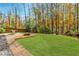 Spacious backyard featuring lush green grass, a fire pit, and a dining area at 4273 Creekrun Cir, Buford, GA 30519