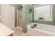 Bathroom with a soaking tub, glass shower, and a decorative window at 4273 Creekrun Cir, Buford, GA 30519