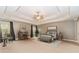 Spacious main bedroom with a tray ceiling, a ceiling fan, and ample natural light at 4273 Creekrun Cir, Buford, GA 30519