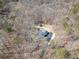 Aerial view of home nestled in the trees, plus outbuilding and winding driveway at 170 River Cove Rdg, Social Circle, GA 30025