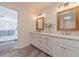 Bathroom featuring double sinks, wood-framed mirrors, and access to the shower and main bedroom at 170 River Cove Rdg, Social Circle, GA 30025