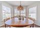 Inviting breakfast nook offers views from large windows, a wooden table and comfortable seating at 170 River Cove Rdg, Social Circle, GA 30025