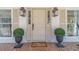 Elegant front entrance featuring a classic door, stylish lanterns, and manicured potted plants at 170 River Cove Rdg, Social Circle, GA 30025