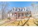 Charming two-story home featuring a welcoming porch and landscaped front yard and American flag at 170 River Cove Rdg, Social Circle, GA 30025