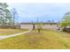 Exterior view of the home featuring a spacious grassy yard, back porch and trees at 6202 Humphries Hill Rd, Austell, GA 30106