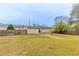 View of the back of the home with a fenced in backyard featuring grass and bare trees at 6202 Humphries Hill Rd, Austell, GA 30106