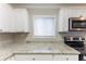 Bright kitchen featuring granite countertops, stainless steel appliances, and crisp white cabinets at 6202 Humphries Hill Rd, Austell, GA 30106