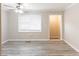 Bright living room with modern ceiling fan, neutral paint, and beautiful gray wood floors at 6202 Humphries Hill Rd, Austell, GA 30106