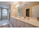 Bathroom features double sinks, white cabinets and a large mirror with ample lighting at 6360 Brookline Ct, Cumming, GA 30040