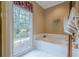 Relaxing bathroom features a soaking tub, large window, and neutral tile at 6360 Brookline Ct, Cumming, GA 30040