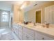 Bright bathroom featuring double sinks with a large mirror and natural light from an arched window at 6360 Brookline Ct, Cumming, GA 30040
