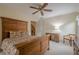 Spacious bedroom with a large wooden bed frame and matching furniture, with good natural light at 6360 Brookline Ct, Cumming, GA 30040