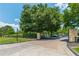 Gated entrance to a community featuring brick columns, decorative iron gates, and manicured landscaping at 6360 Brookline Ct, Cumming, GA 30040