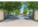 A grand gated entrance welcomes you to the community, framed by stone pillars and lush trees at 6360 Brookline Ct, Cumming, GA 30040