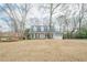 Traditional home with large front yard and covered porch featuring classic columns and double garage at 6360 Brookline Ct, Cumming, GA 30040