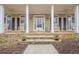 Charming front porch featuring rocking chairs, stone accents, and a welcoming entrance, great for relaxing outdoors at 6360 Brookline Ct, Cumming, GA 30040