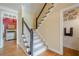 Traditional hallway with hardwood floors and staircase with black and white railings at 6360 Brookline Ct, Cumming, GA 30040