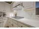 Close-up of modern kitchen with stainless gas cooktop and white countertops and cabinetry at 6360 Brookline Ct, Cumming, GA 30040