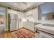 Bright kitchen with white cabinets, stainless steel appliances, and hardwood floors at 6360 Brookline Ct, Cumming, GA 30040