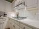 Modern kitchen featuring white cabinets, quartz countertops, stainless steel range hood and tiled backsplash at 6360 Brookline Ct, Cumming, GA 30040