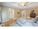 Comfortable main bedroom with tray ceiling, hardwood floors, and ensuite bathroom entrances at 6360 Brookline Ct, Cumming, GA 30040