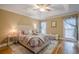 A cozy primary bedroom with a tray ceiling, hardwood floors, and plenty of natural light at 6360 Brookline Ct, Cumming, GA 30040