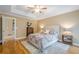 Inviting main bedroom with hardwood floors, a ceiling fan, and view to the ensuite bathroom at 6360 Brookline Ct, Cumming, GA 30040