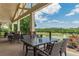 Covered patio featuring outdoor seating with views of the golf course and a tranquil lake at 6360 Brookline Ct, Cumming, GA 30040