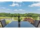 Outdoor dining area overlooking a scenic lake and golf course, perfect for relaxing meals at 6360 Brookline Ct, Cumming, GA 30040
