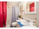 This bathroom features a shower, vanity, mirror, and bright, red window treatments at 999 Chestnut Oak Ct, Lawrenceville, GA 30046