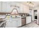 Bright kitchen with white cabinets, stainless steel appliances, and a convenient laundry area at 999 Chestnut Oak Ct, Lawrenceville, GA 30046