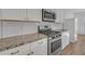 Kitchen with stainless steel appliances, granite countertops, white cabinets, and subway tile backsplash at 1584 Long Shadow Ln, Snellville, GA 30078