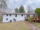 Exterior view of a white brick home with a spacious backyard and a wooden deck, perfect for outdoor living at 341 Baggett Cir, Lawrenceville, GA 30044