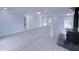 Spacious finished basement with stone accent wall, modern lighting, and newly installed light grey floors at 341 Baggett Cir, Lawrenceville, GA 30044