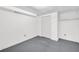 Unfinished basement features a carpeted floor, white walls, closet and shelving space at 7025 Kimberly Mill Rd, Atlanta, GA 30349