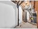 Unfinished basement with pipes and an old water heater at 7025 Kimberly Mill Rd, Atlanta, GA 30349