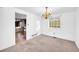 Dining area featuring neutral carpet, white walls, a chandelier, and a view of the kitchen at 7025 Kimberly Mill Rd, Atlanta, GA 30349