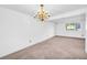 Dining area with neutral carpet, white walls, a chandelier, and a large window providing natural light at 7025 Kimberly Mill Rd, Atlanta, GA 30349