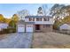 Two-story home featuring brick accents, vinyl siding, an attached two-car garage, and a driveway in a residential area at 7025 Kimberly Mill Rd, Atlanta, GA 30349